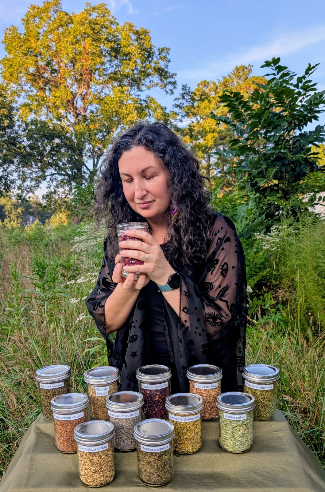 LeAnna herbalist and astrologer behind her traveling apothecary setup